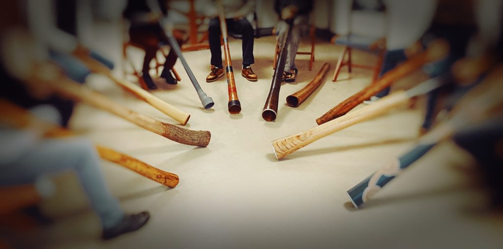 Didgeridoos laid out in a circle during a group meeting